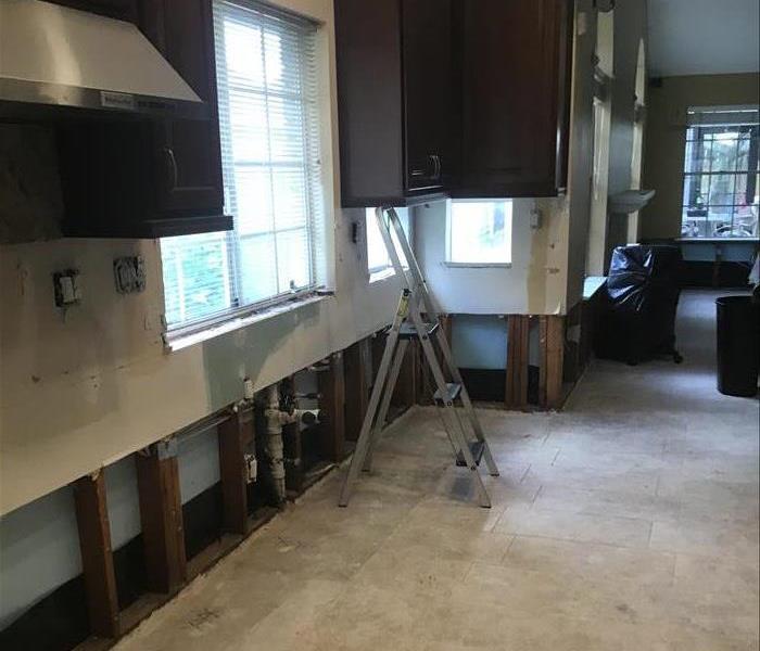 kitchen with appliances and drywall removed from storm damage
